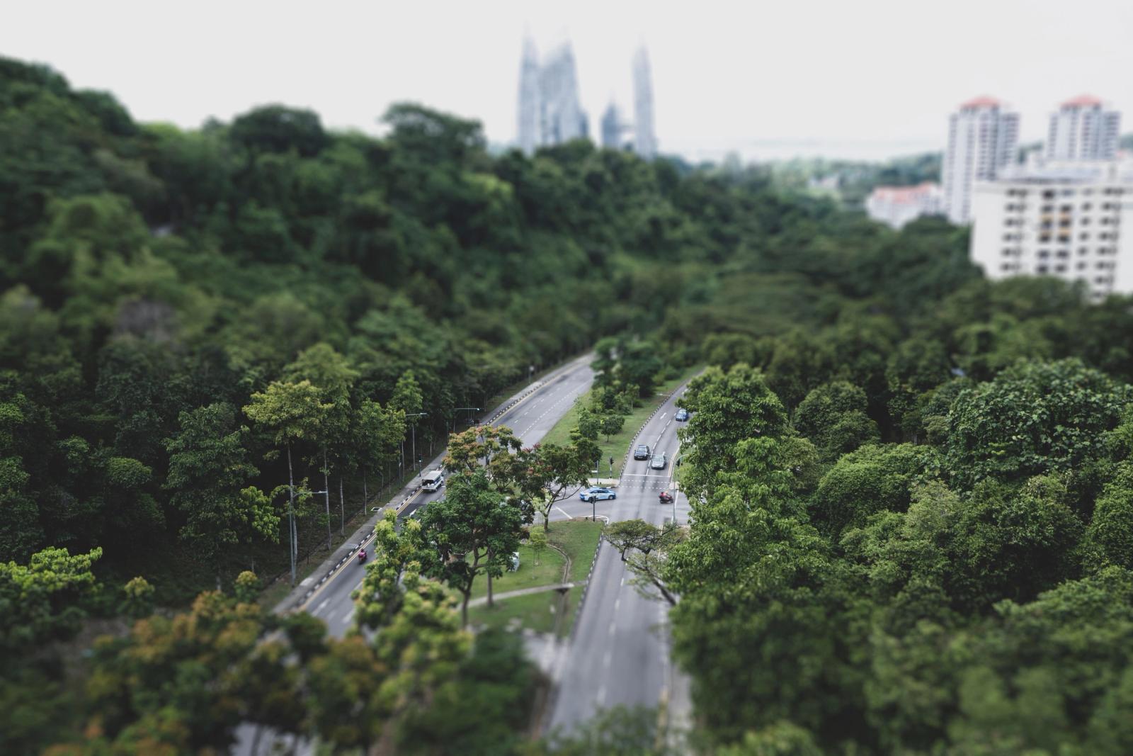 A beautiful aerial view of Singapore's green urban landscape featuring highways amidst lush trees