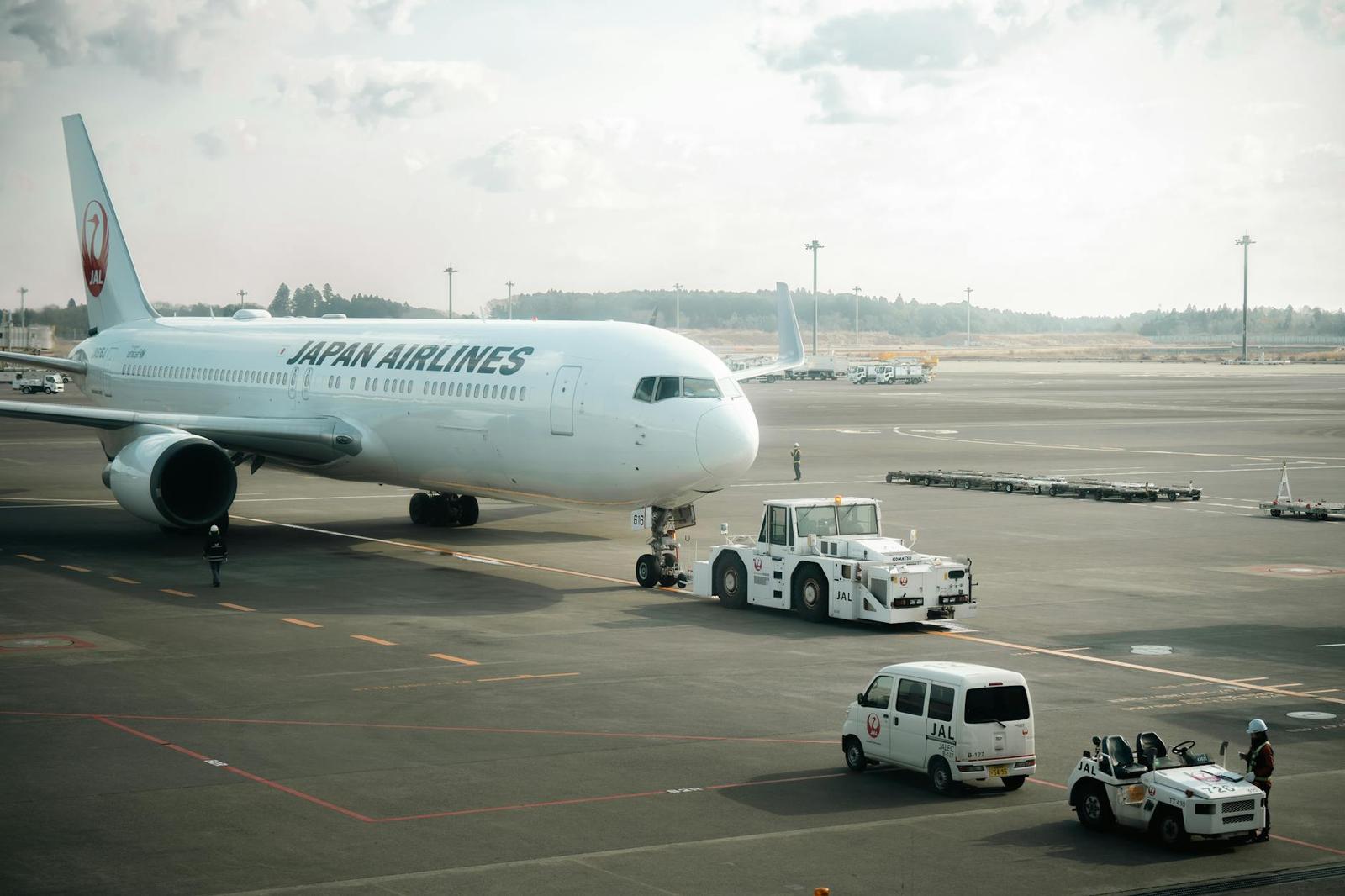A passenger jet on the tarmac with ground service vehicles alongside