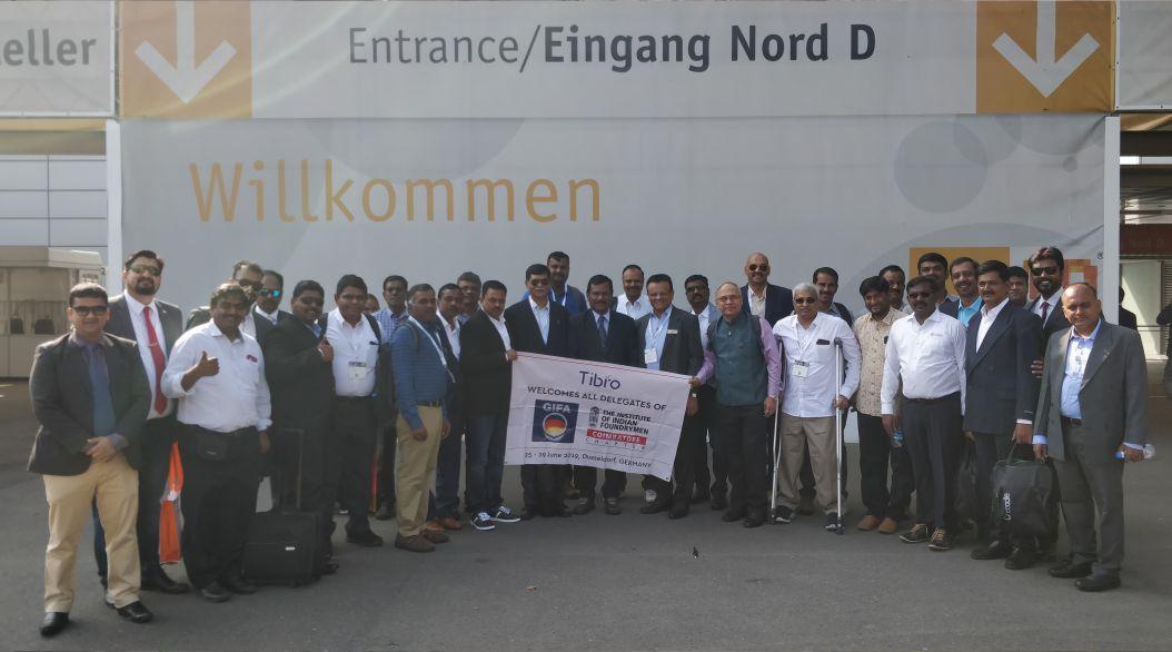 A large group of professionals posing with a 'Tibro' banner