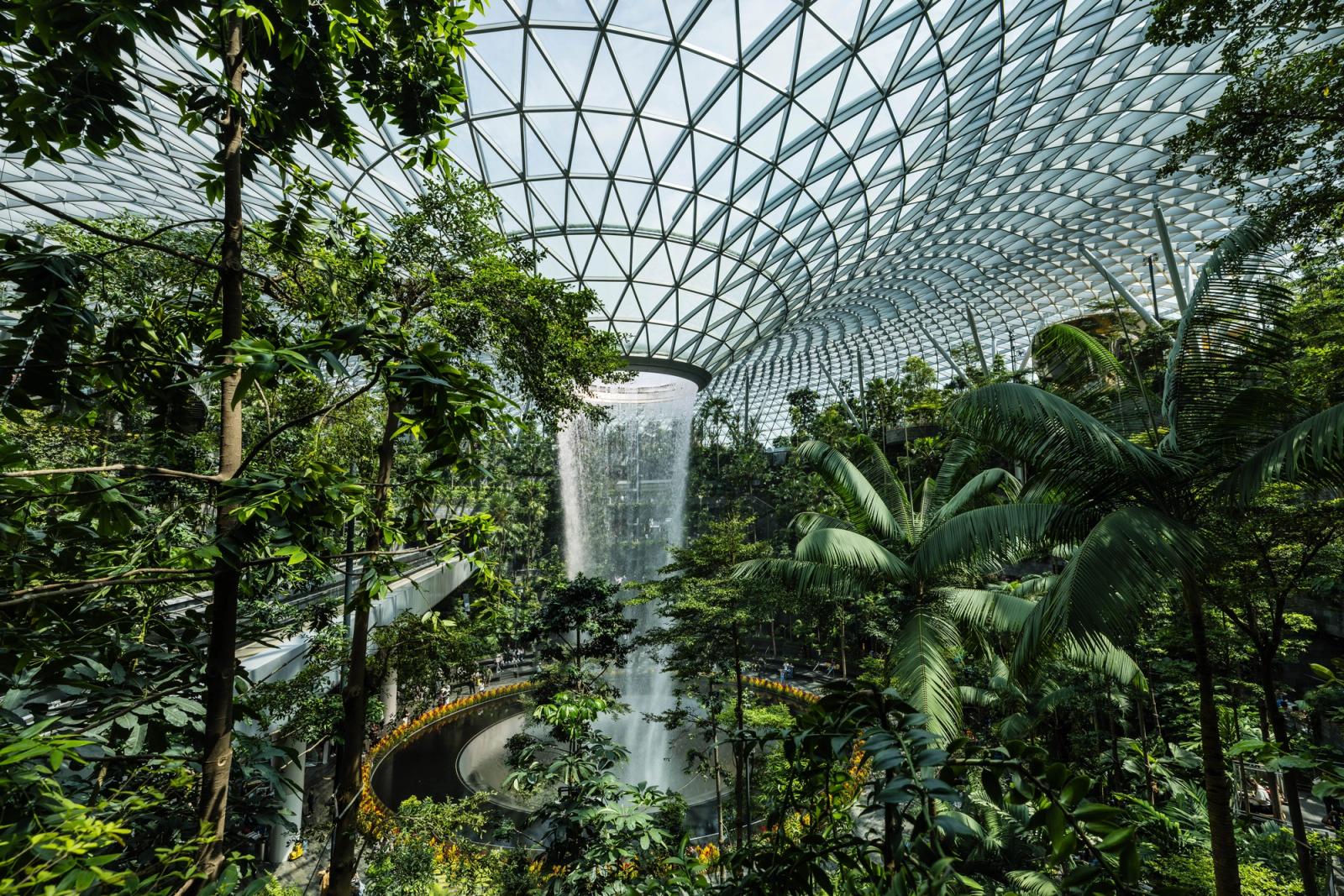 Magnificent indoor waterfall surrounded by tropical greenery inside Jewel Changi Airport, Singapore