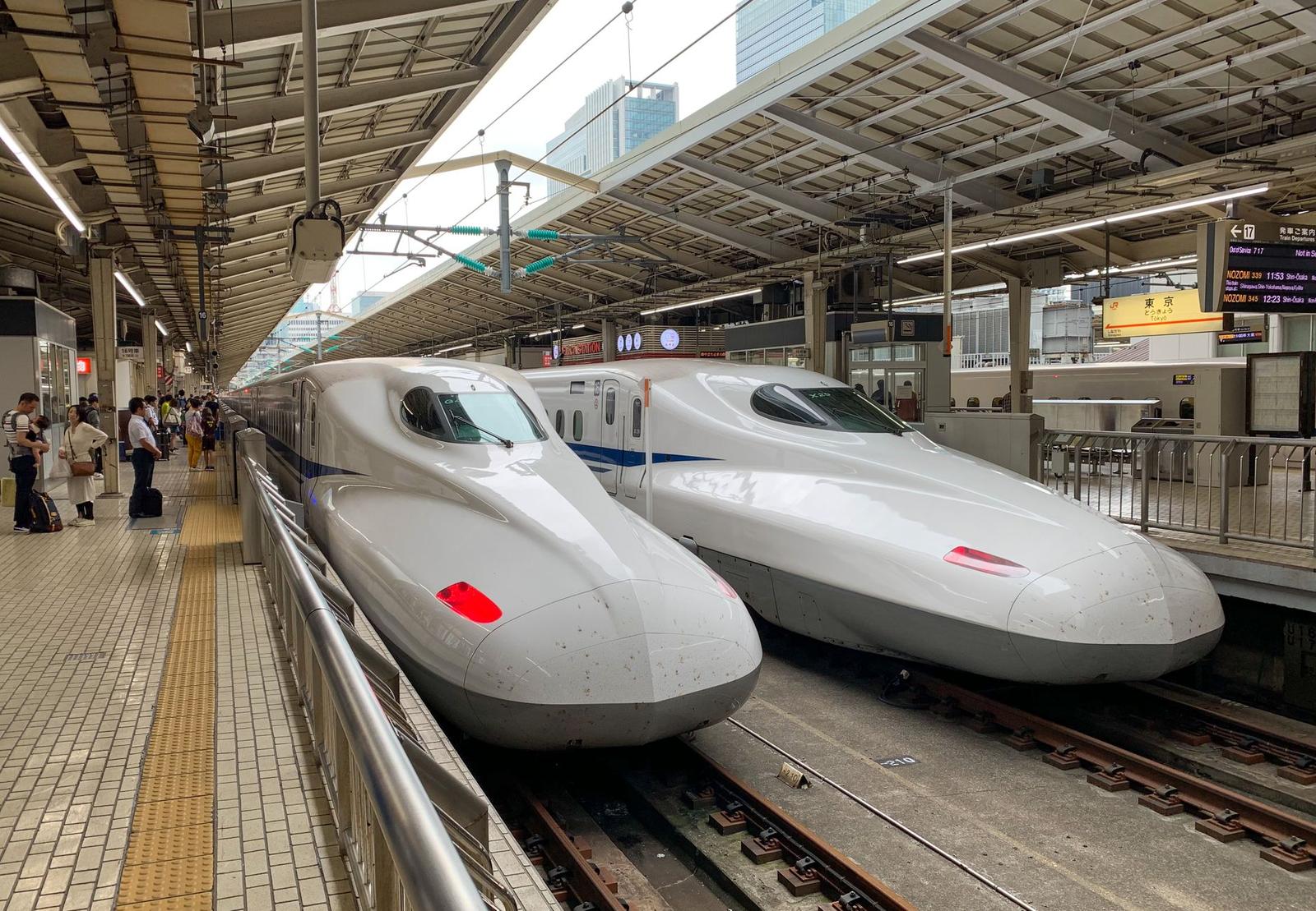 Two sleek shinkansen trains at Tokyo Station, Japan, waiting for passengers