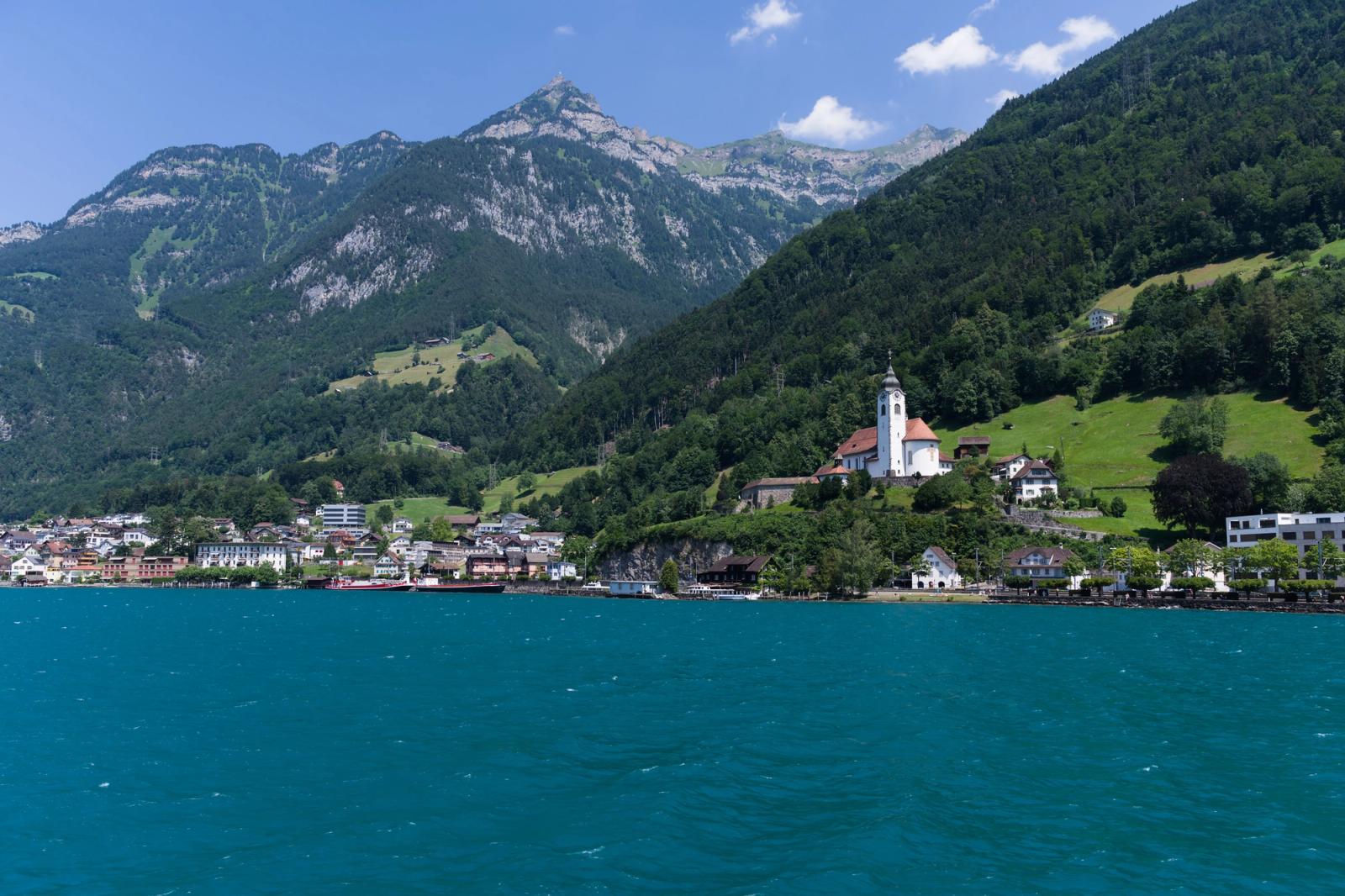 Stunning view of mountains and lake with a charming village in Switzerland on a sunny day