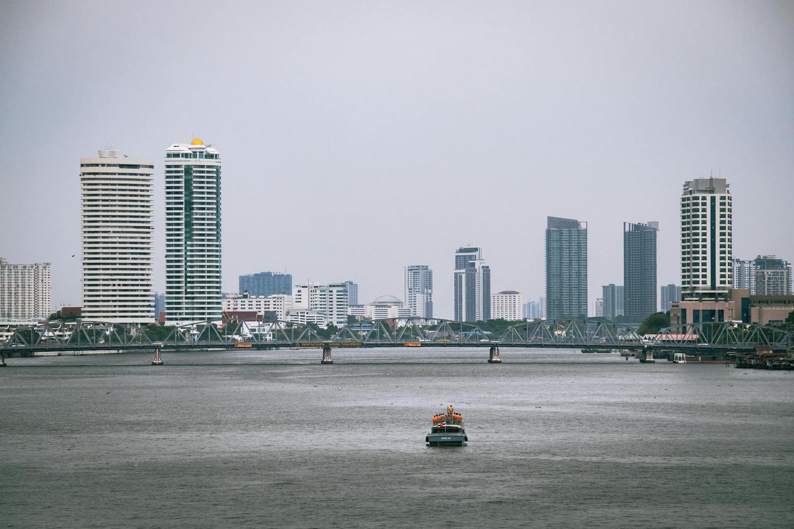 River skyline with a bridge and a small ferry crossing