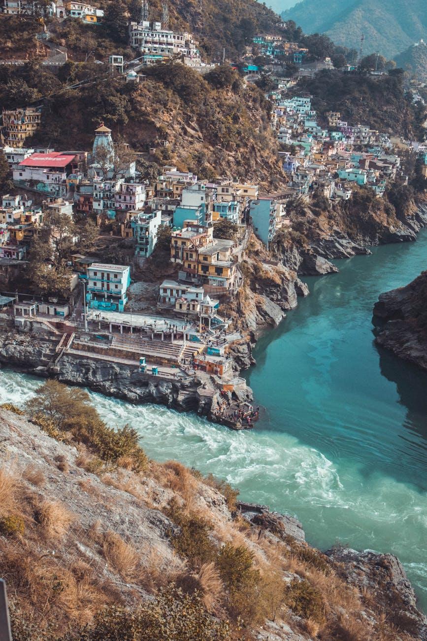 Picturesque view of Rishikesh, India with colorful buildings perched on rocky hills by the Ganges River