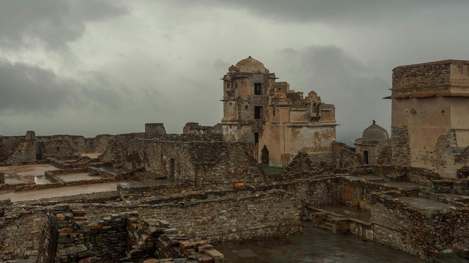 Weathered stone fort ruins with a domed tower under an overcast sky