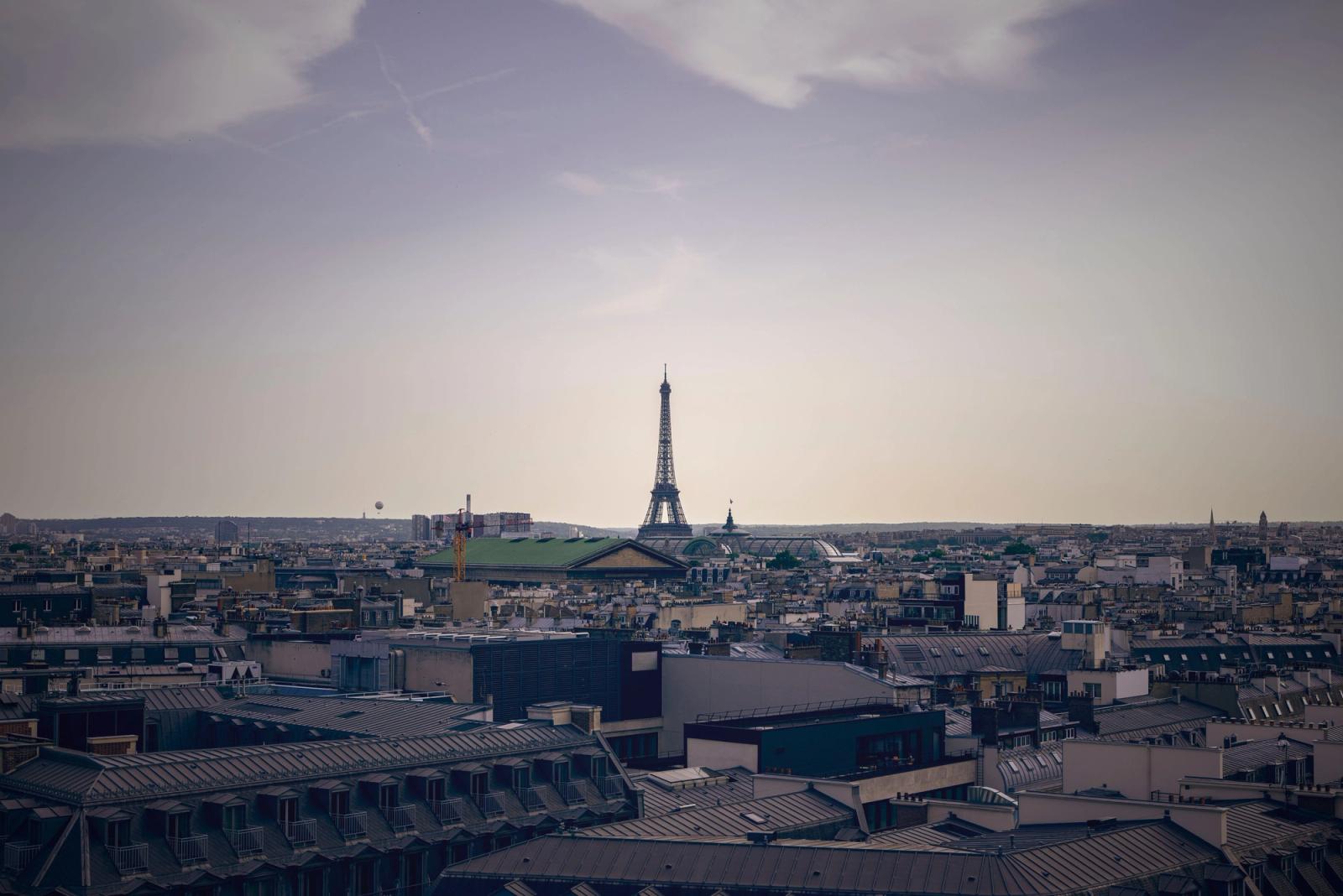 Distant view of Paris skyline featuring the Eiffel Tower against a clear sky