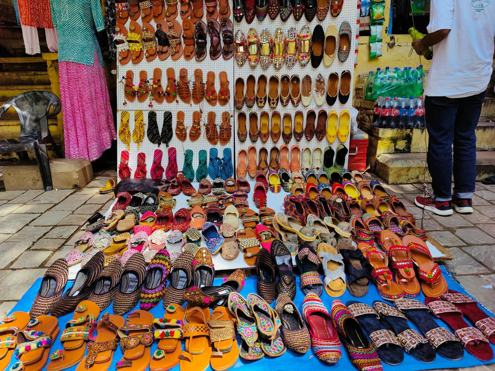 Colorful traditional footwear laid out at an outdoor market stall