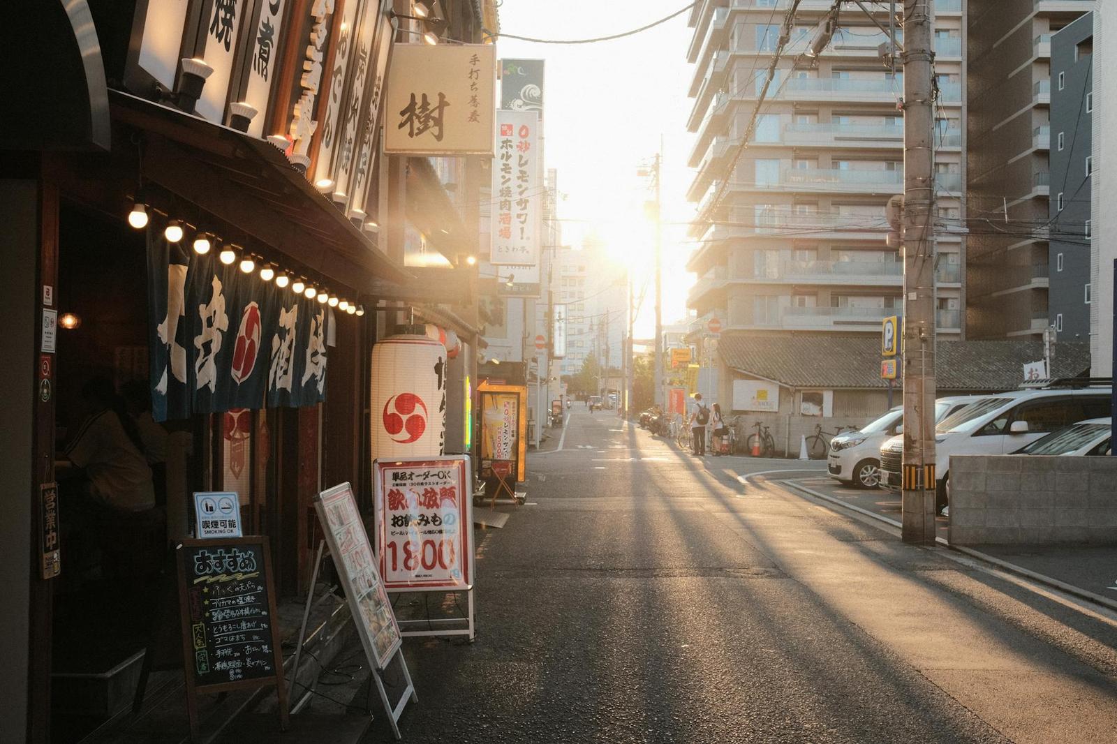 A lantern-lit restaurant storefront on a city street at sunrise