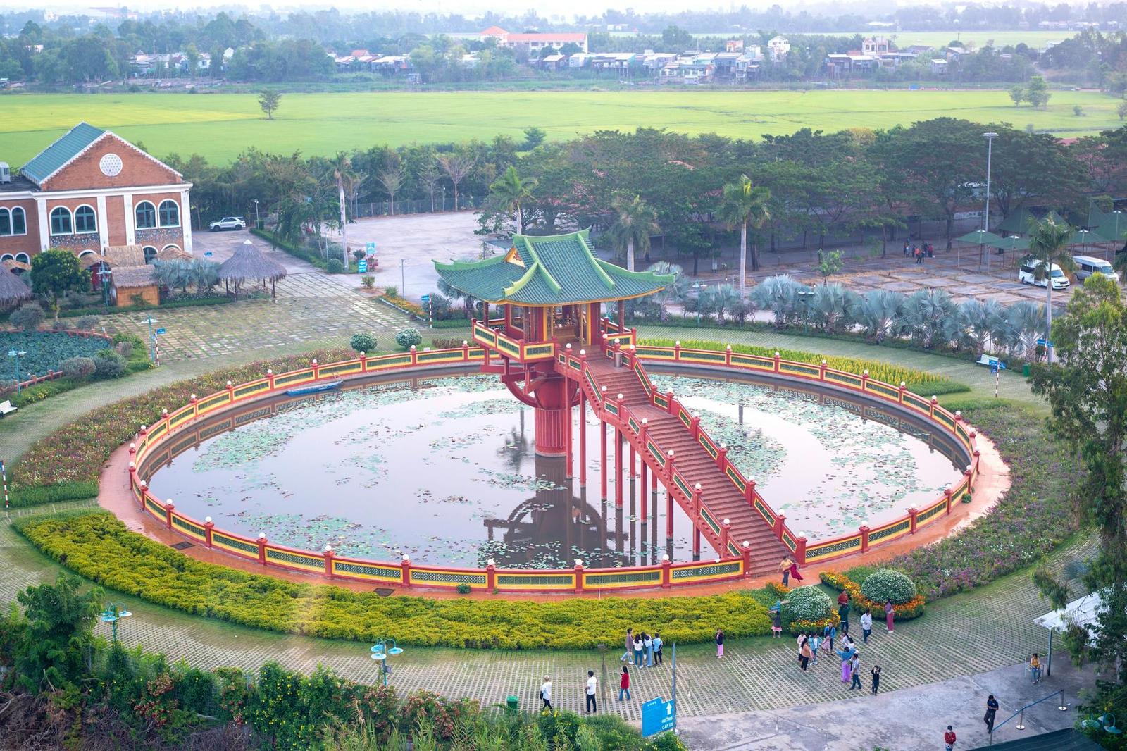 Aerial view of a Vietnamese pagoda surrounded by a pond and green landscape
