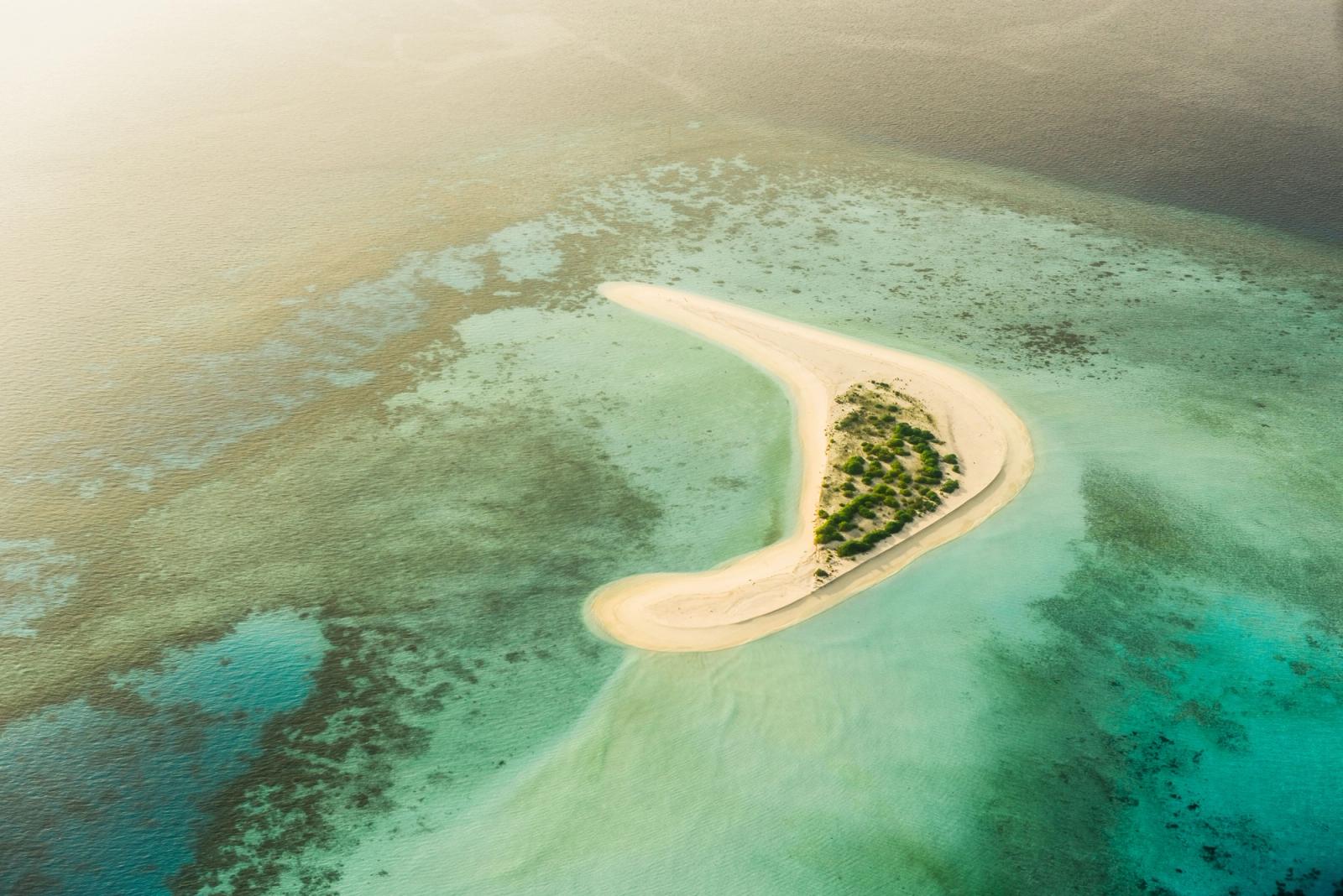 Stunning aerial view of a secluded sandbank surrounded by turquoise waters in the Maldives