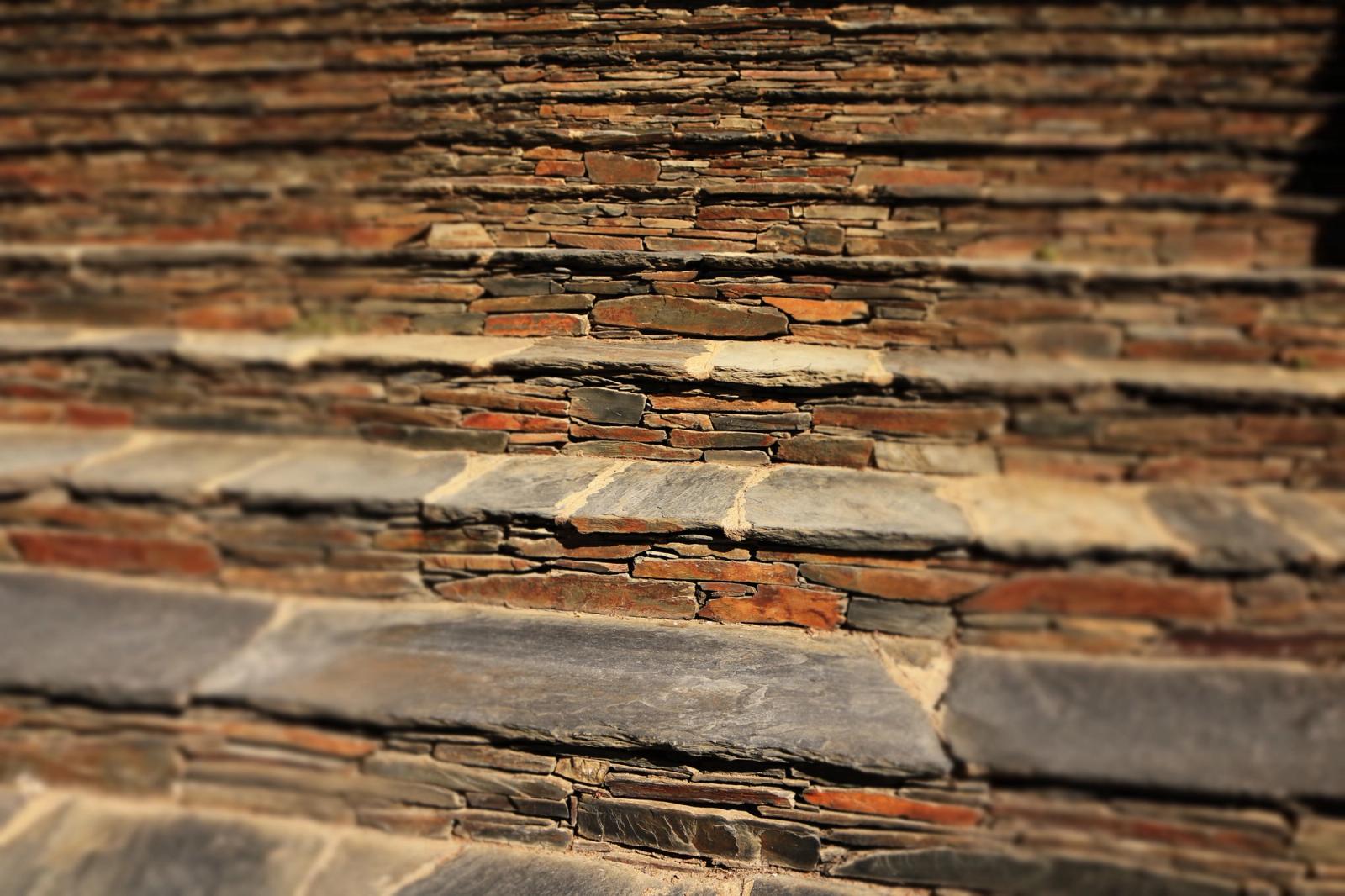 Close-up of a textured stone staircase with a rustic and symmetrical design. Ideal for backgrounds