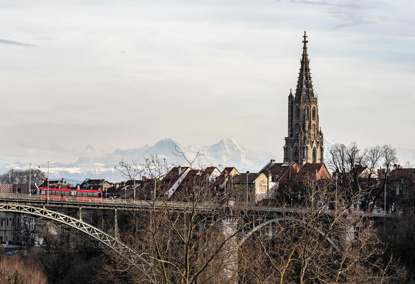 View of Bern Cathedral and bridge with snowy mountains in the background, Switzerland
