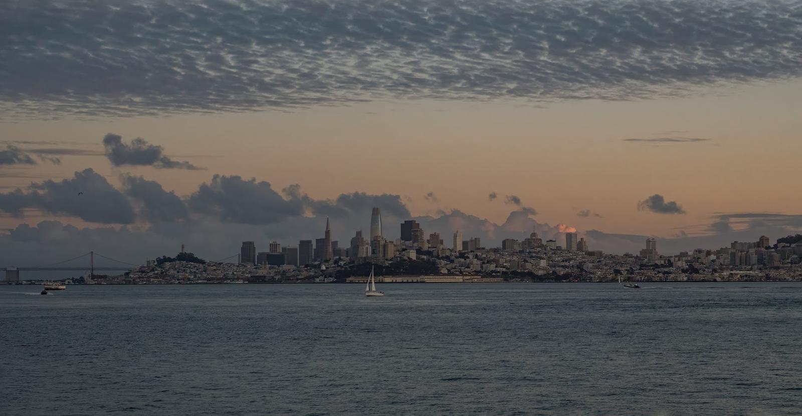 City skyline silhouetted across the water at dusk