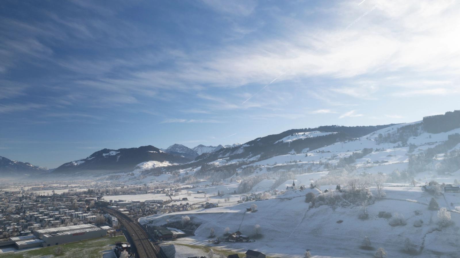 Aerial view of Altendorf, Schwyz, Switzerland with snow-covered mountains and blue sky