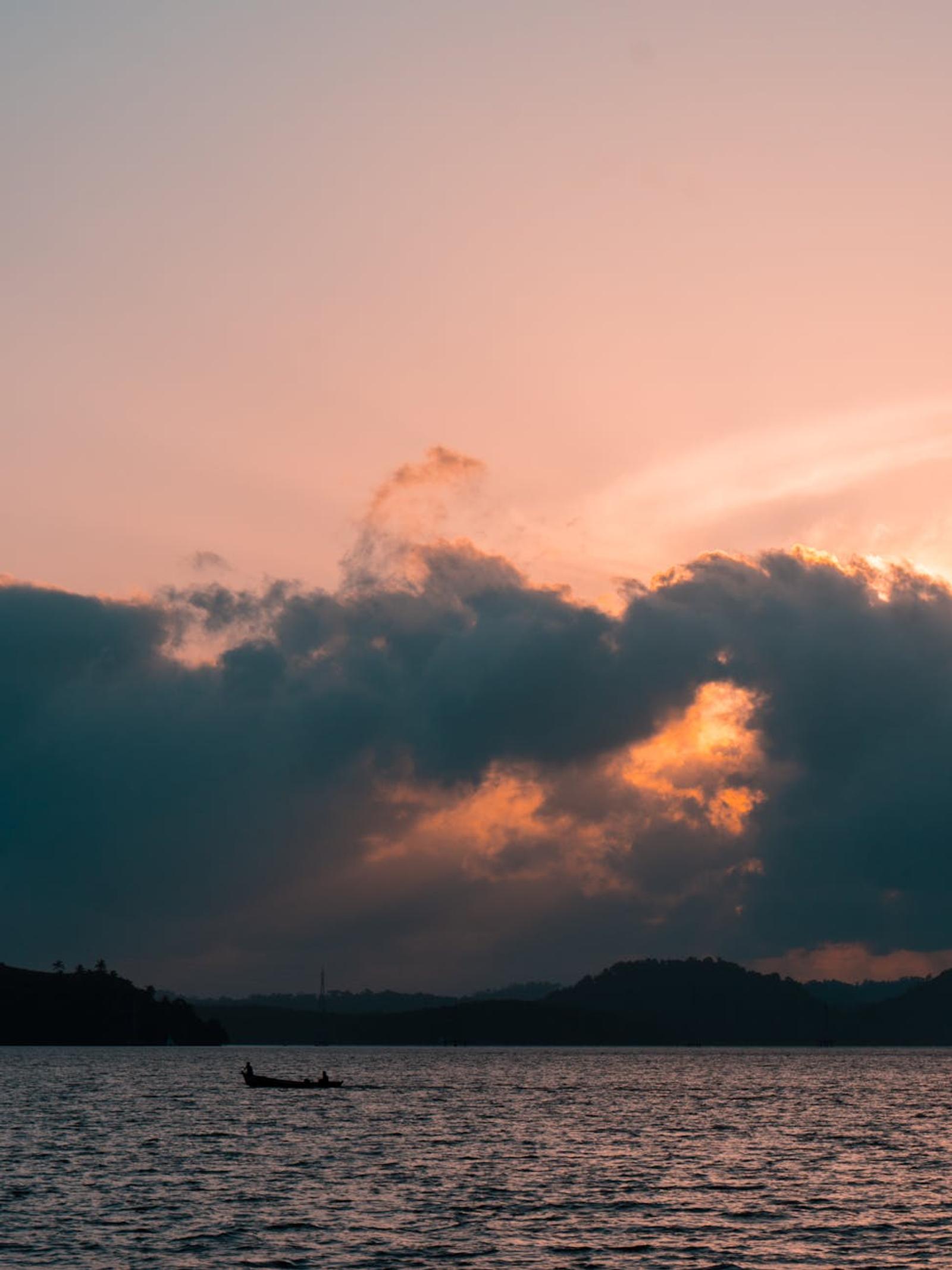 A tranquil sunset with a boat silhouette over the Andaman Sea in Port Blair, India