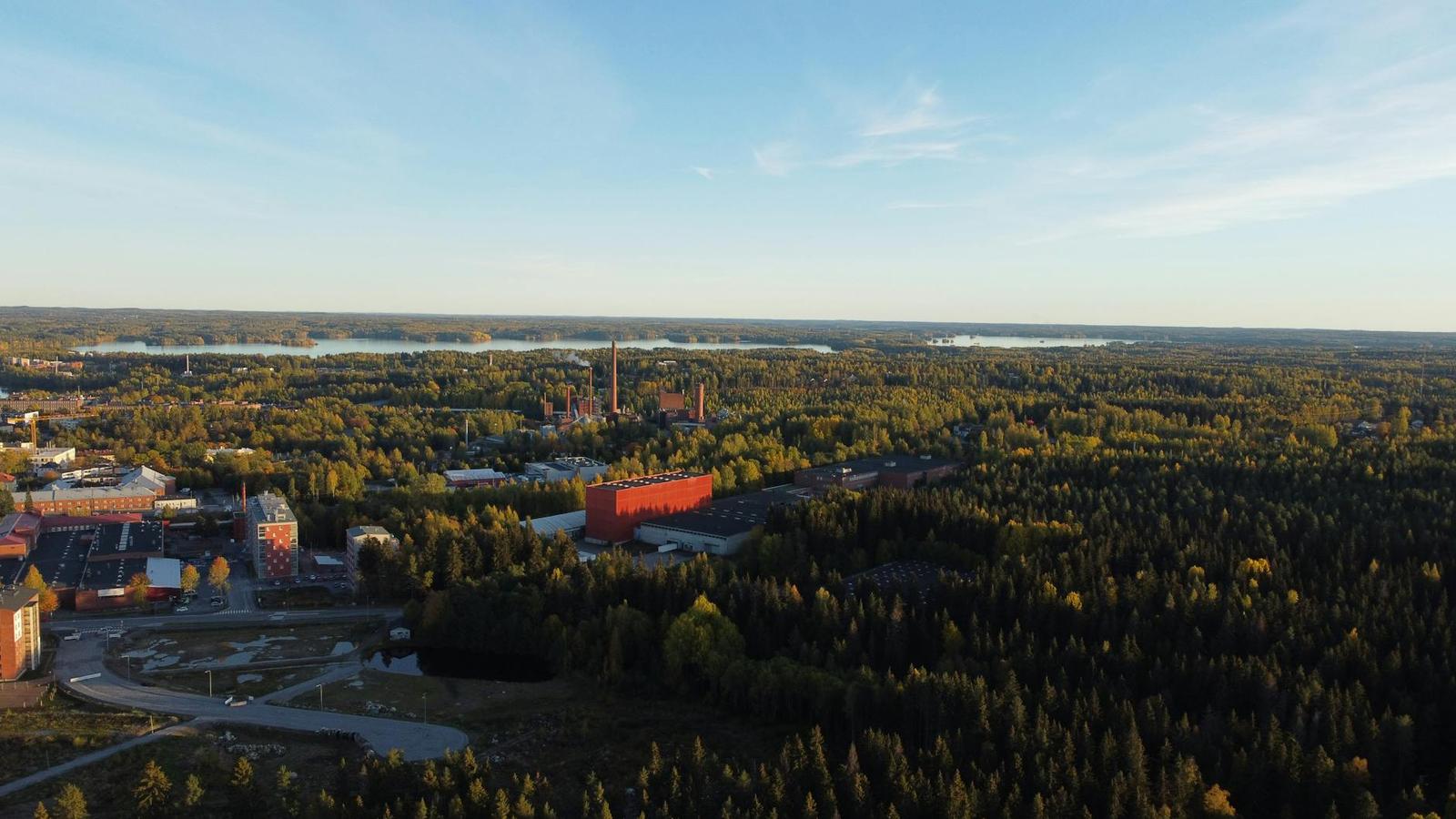 Aerial view of a small town amid forest and lakes at sunset