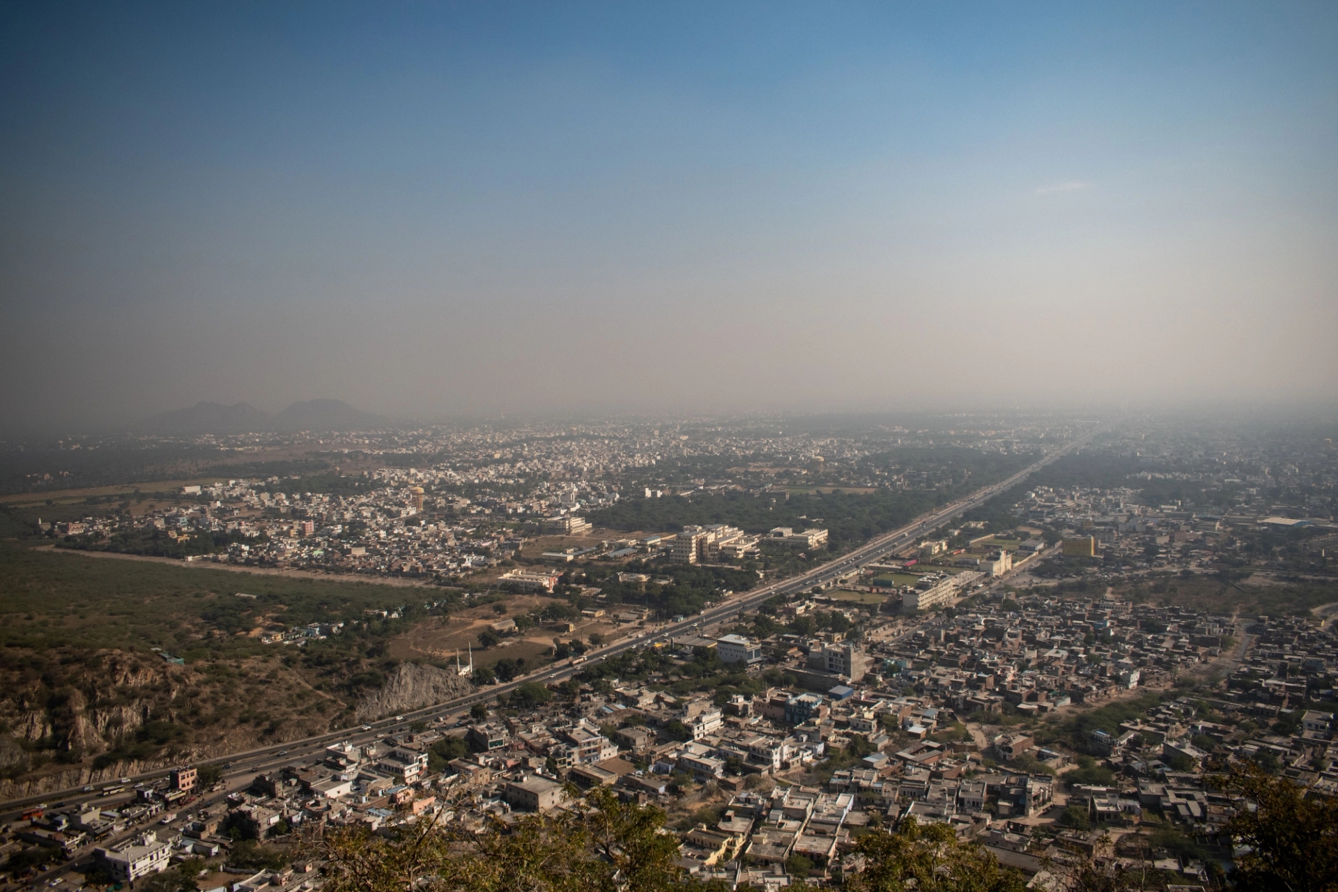 Aerial view of Jaipur city, showcasing the expansive urban landscape under a clear blue sky