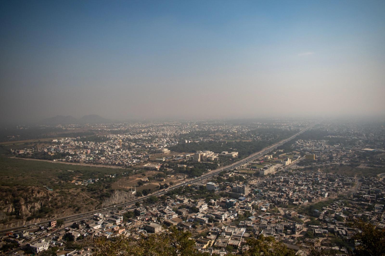 Aerial view of Jaipur city, showcasing the expansive urban landscape under a clear blue sky