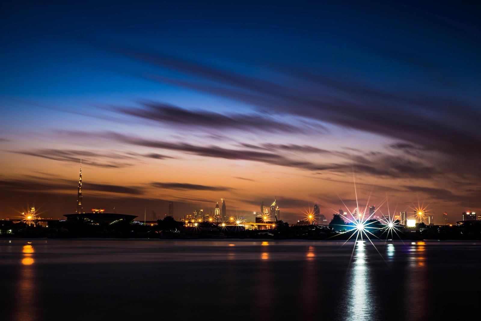 Stunning view of the Dubai skyline at twilight, reflected in calm water