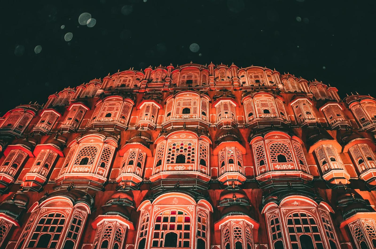 Hawa Mahal's tiered latticed windows lit in pink and gold at night