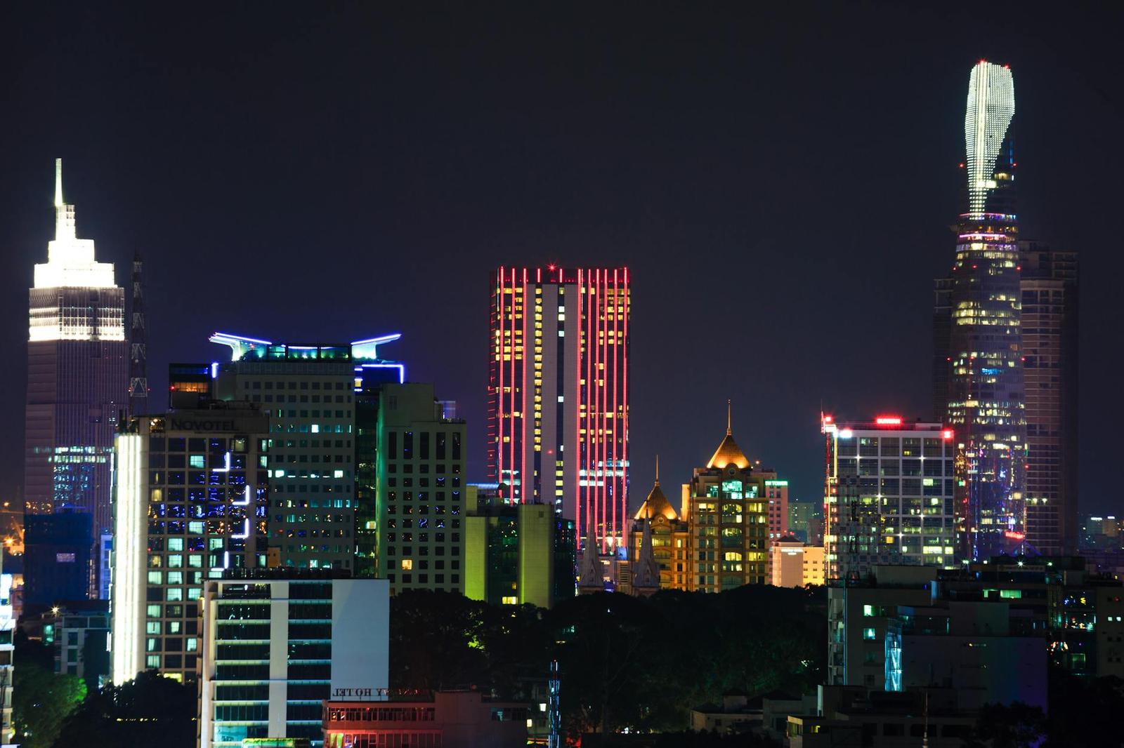 Illuminated skyscrapers and a tapered spire lighting up the night skyline