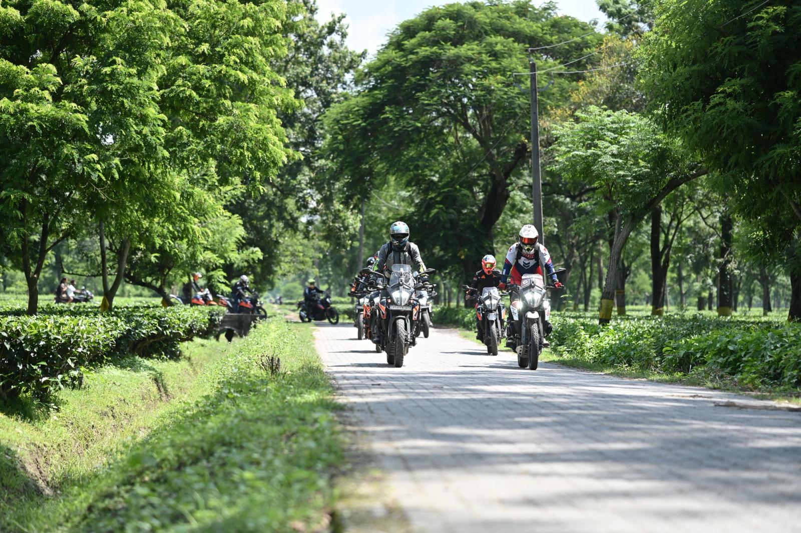 A group of motorcyclists enjoying a ride through a green pathway in Guwahati, India