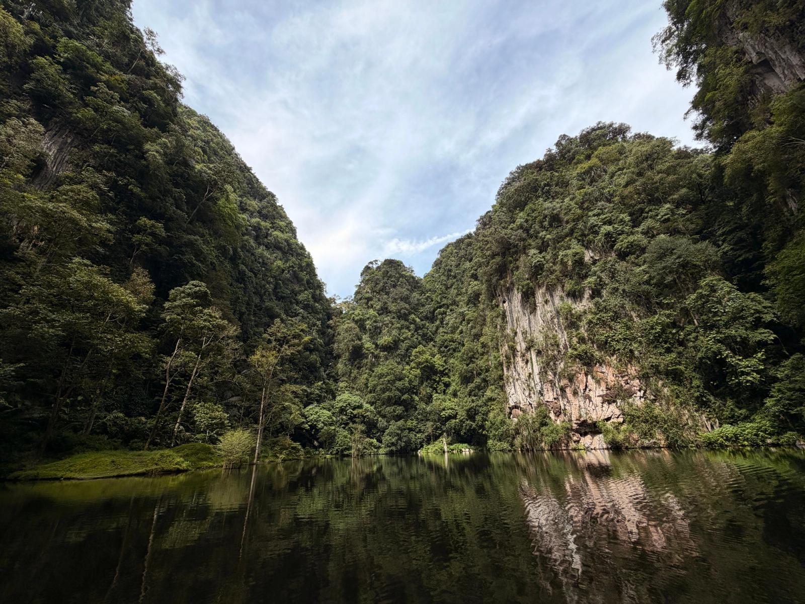 A tranquil view of limestone hills and a serene lake at Gunung Lang, Ipoh, Malaysia