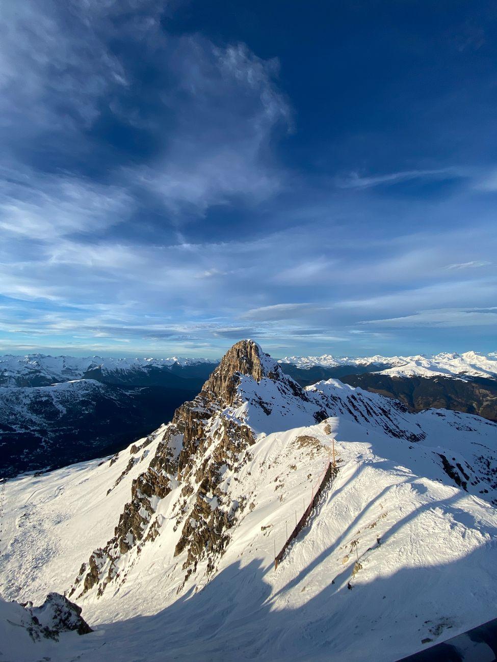 Stunning view of snow-covered peaks at Courchevel, France, under a clear blue sky in winter