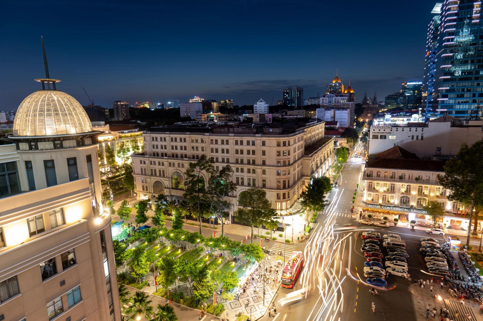 Vibrant night view of Ho Chi Minh City with bustling streets, iconic landmarks, and light trails