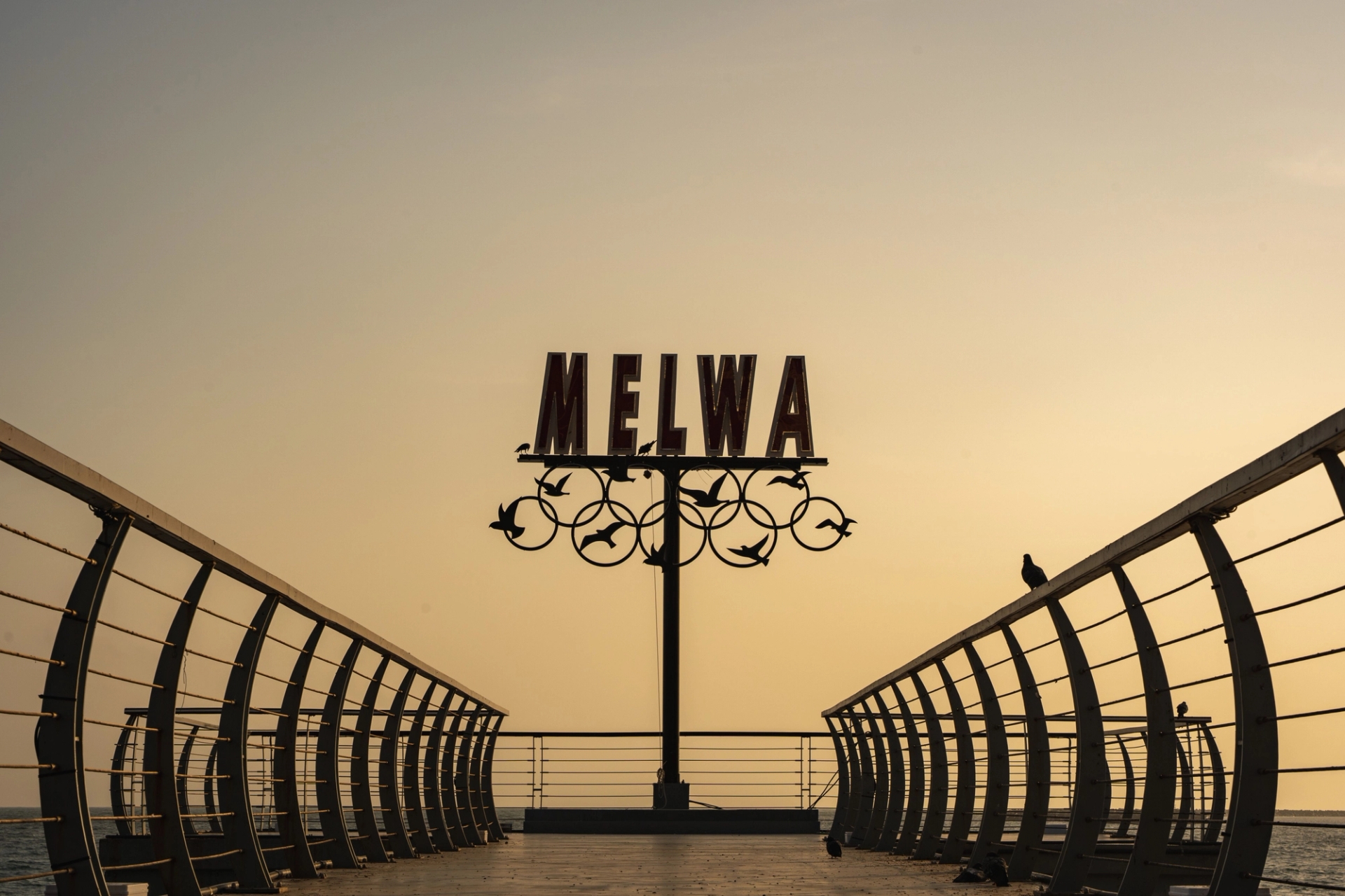 Silhouette of the Melwa sign at Colombo's pier during sunset, Sri Lanka