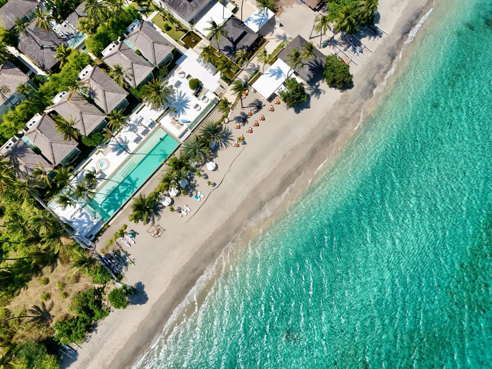 Aerial shot of a luxury resort with beachfront view and turquoise waters in Lombok, Indonesia