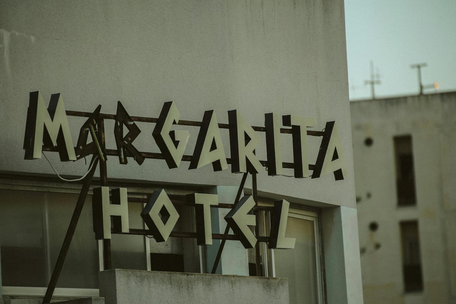 Margarita Hotel sign in wooden letters against a concrete facade