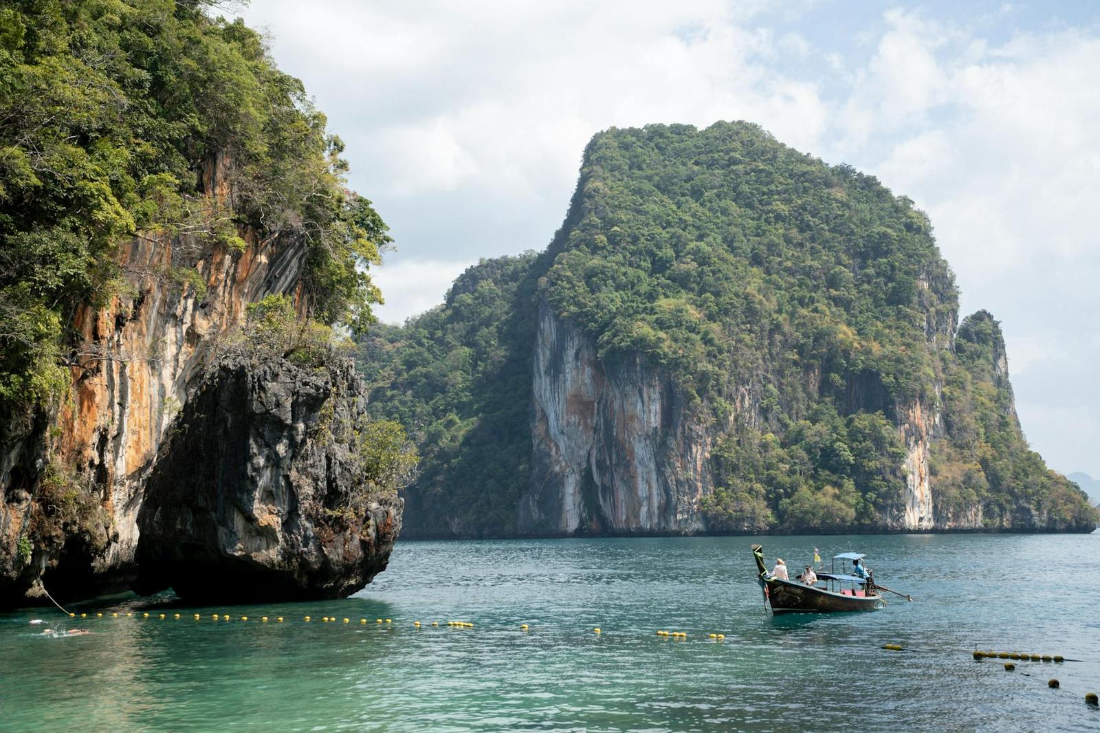 Longtail boat anchored beside towering limestone karsts