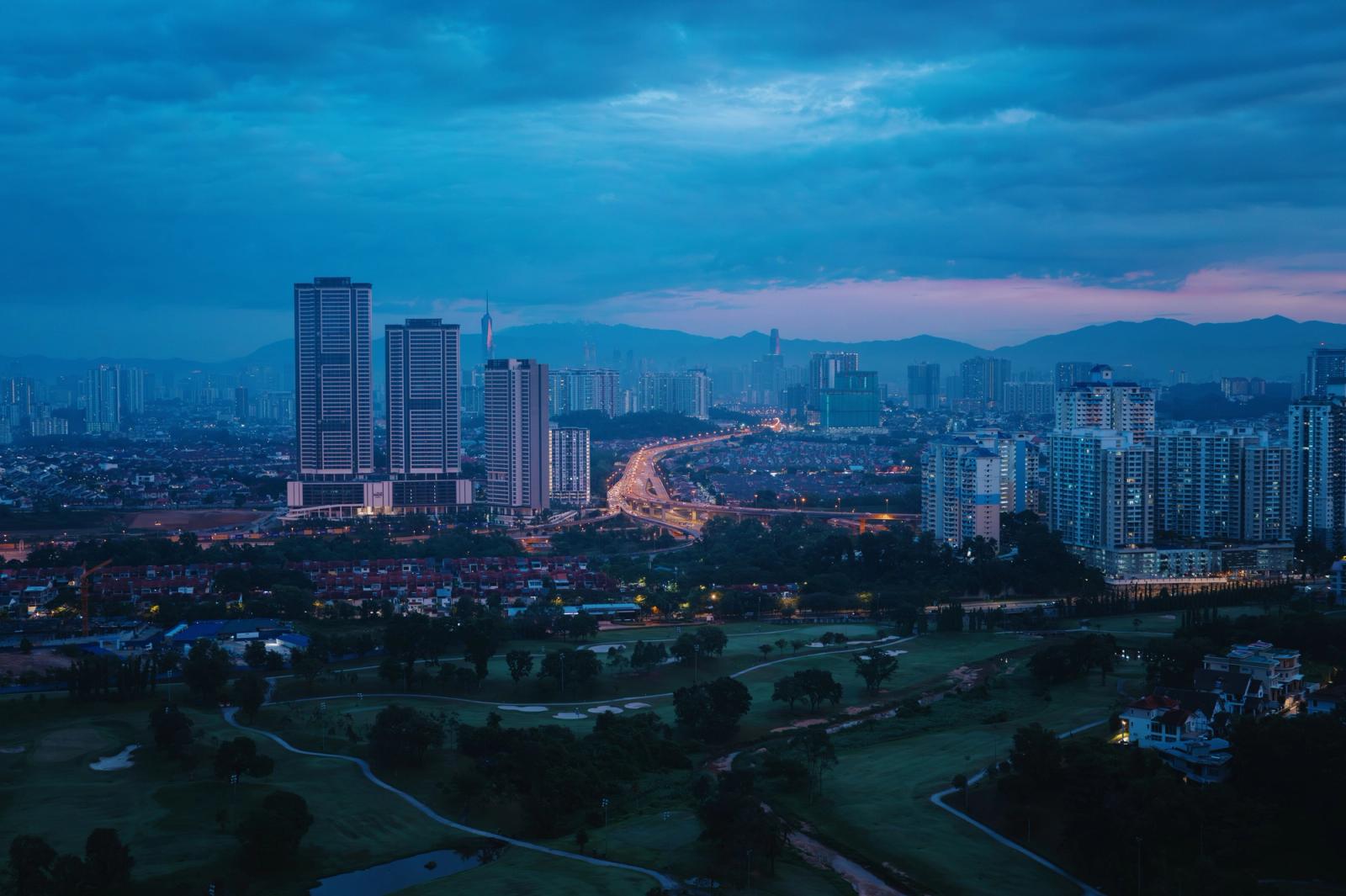 A tranquil view of Kuala Lumpur's skyline during the blue hour with soft city lights