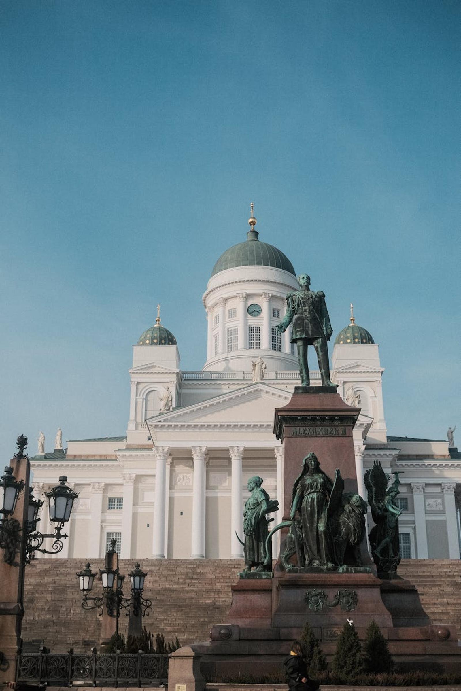 View of Helsinki Cathedral, Finland with a bronze statue in front during daylight hours