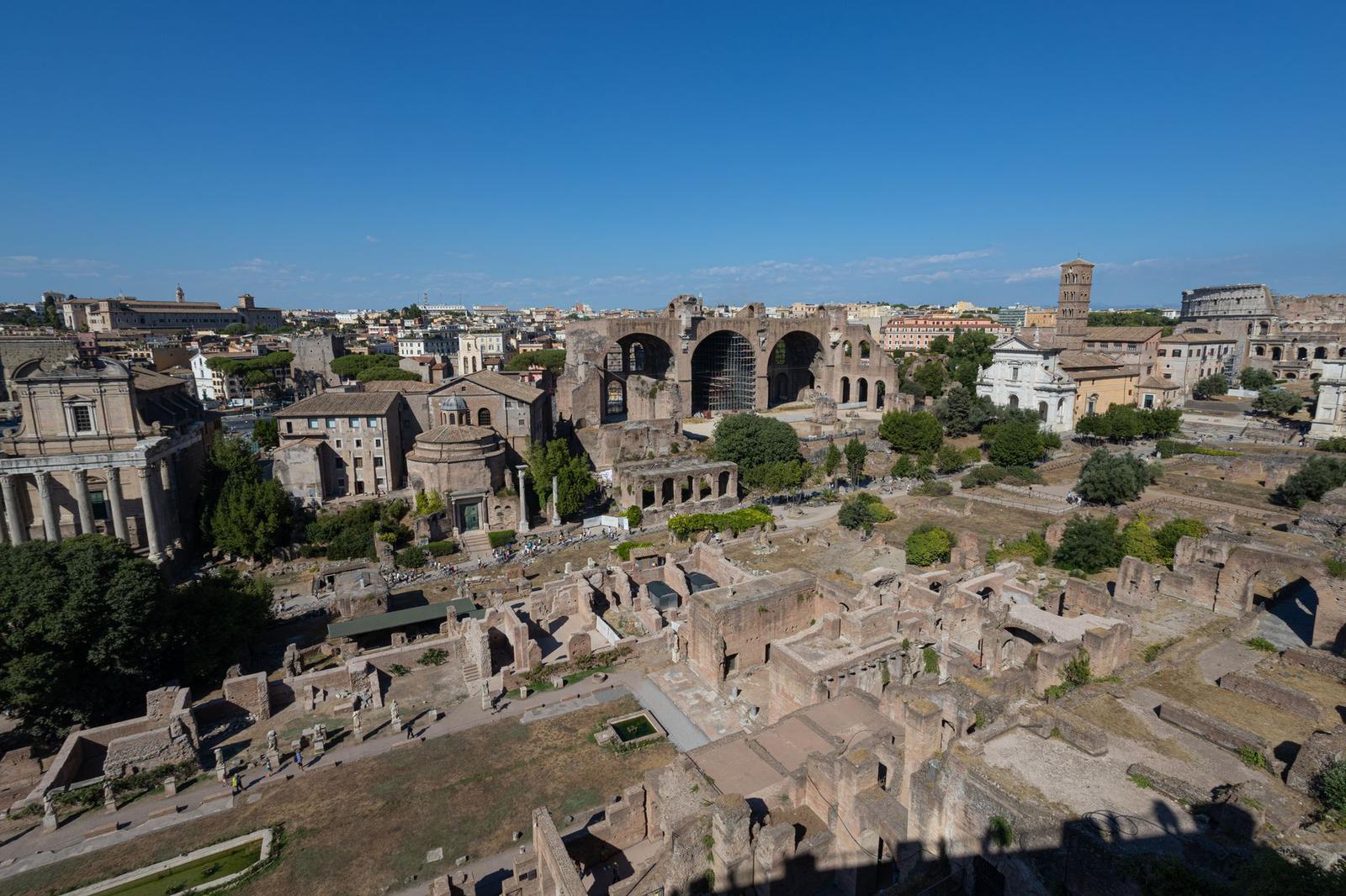 Excavated ancient ruins with old columns and arches under a clear sky
