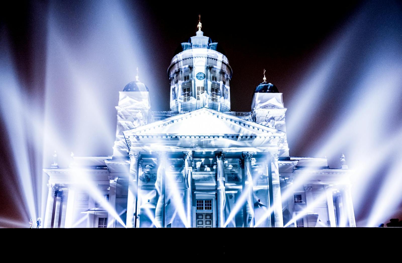 A domed cathedral lit up by dramatic white spotlights at night