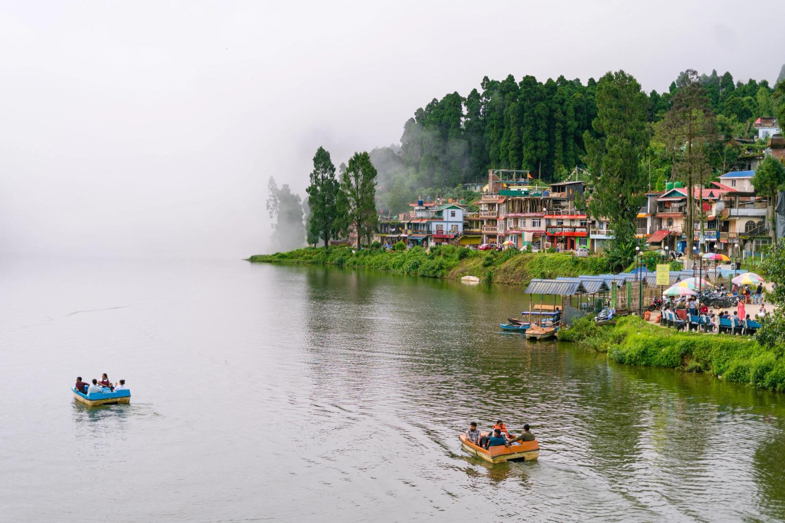 Explore the serene beauty of Mirik Lake amidst mist and lush green hills in West Bengal, India