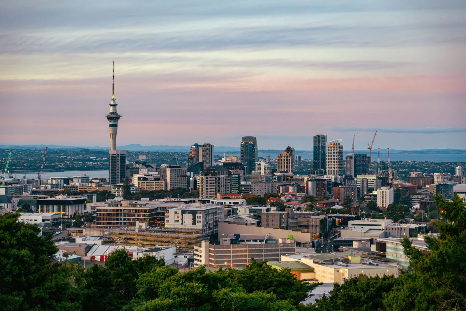 Captivating view of Auckland's skyline at dusk featuring the iconic Sky Tower under a colorful sky