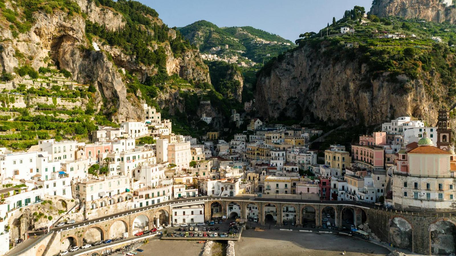 Pastel-colored coastal town clustered on cliffs above a river mouth