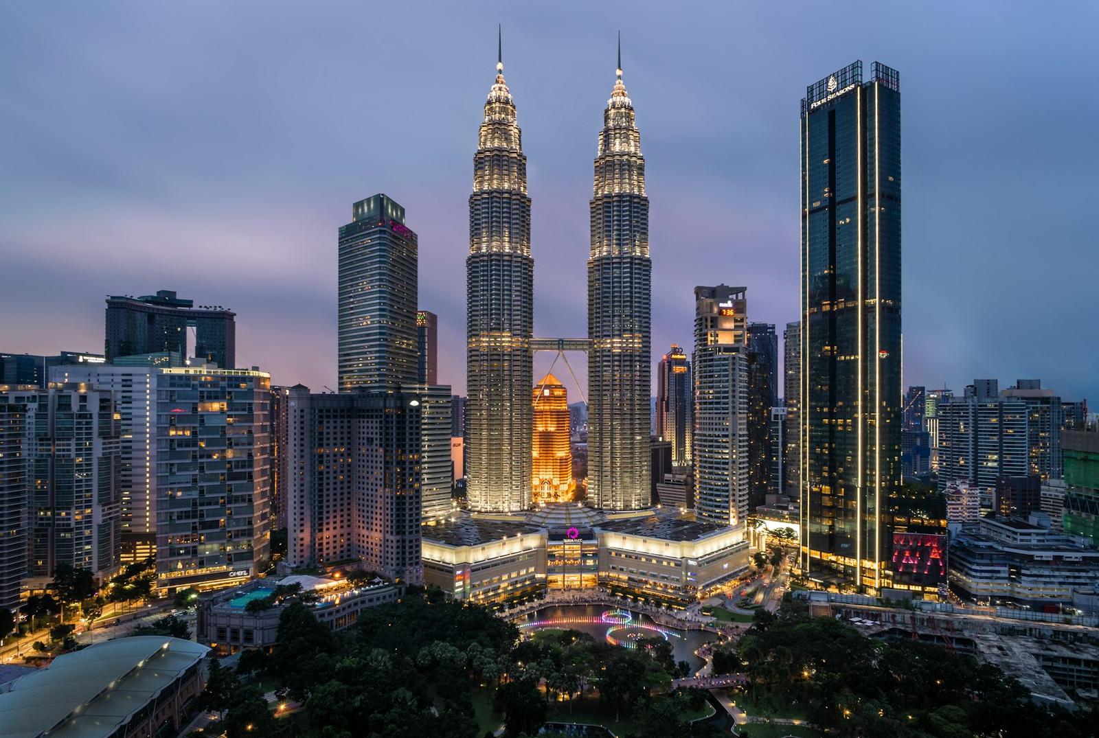 The Petronas Towers rising over the Kuala Lumpur skyline at dusk