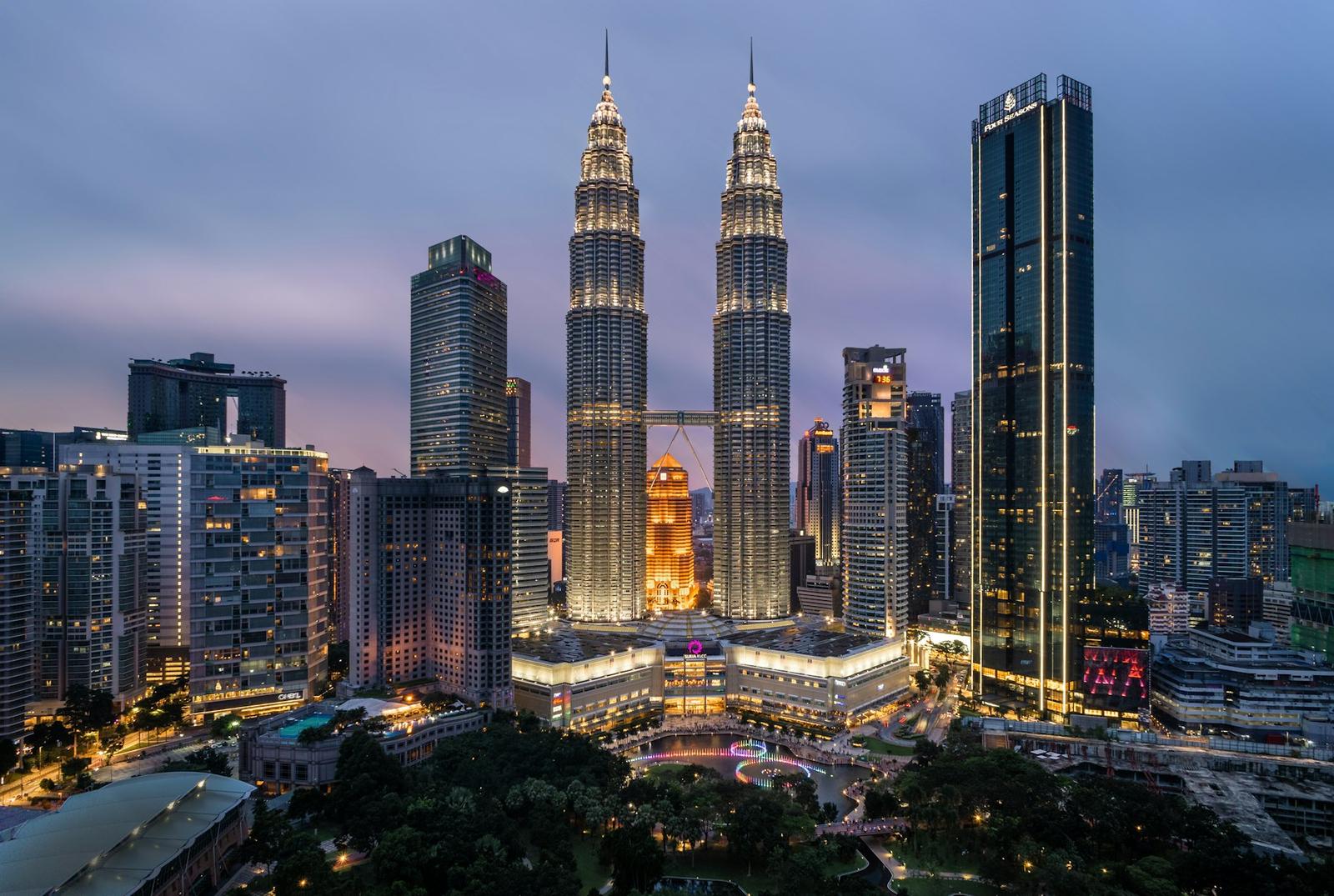 The Petronas Towers rising over the Kuala Lumpur skyline at dusk