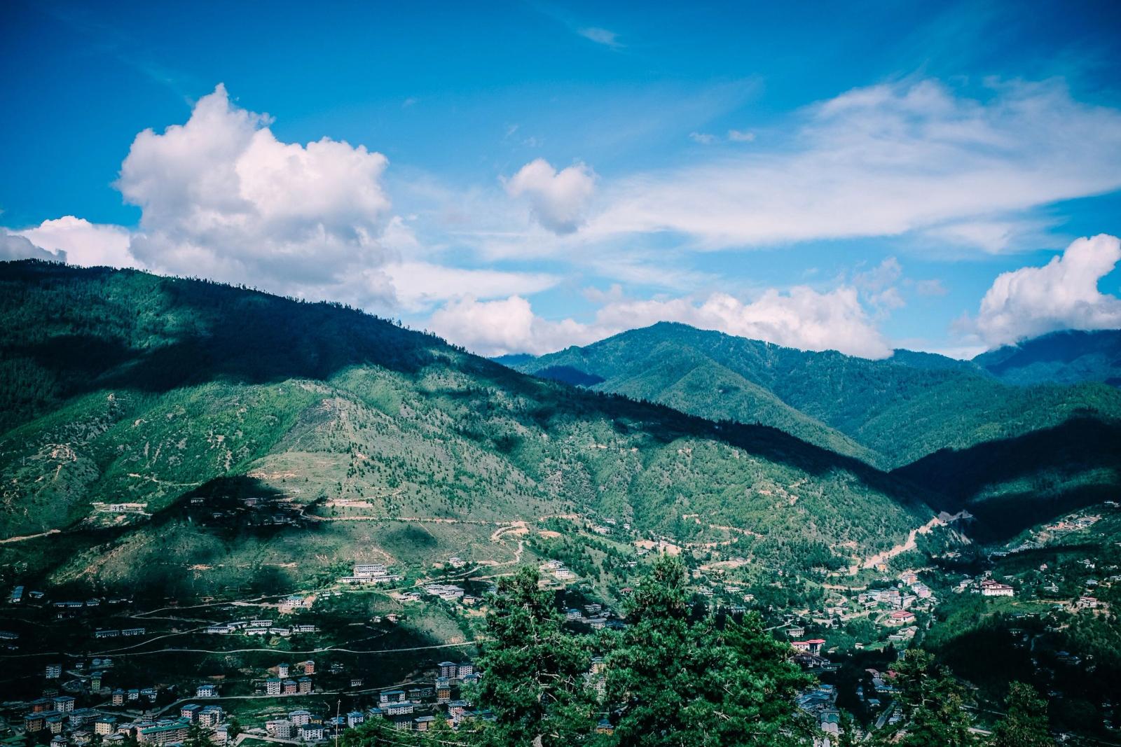 Vibrant view of Bhutan's mountains and valleys under a clear blue sky, showcasing nature's beauty
