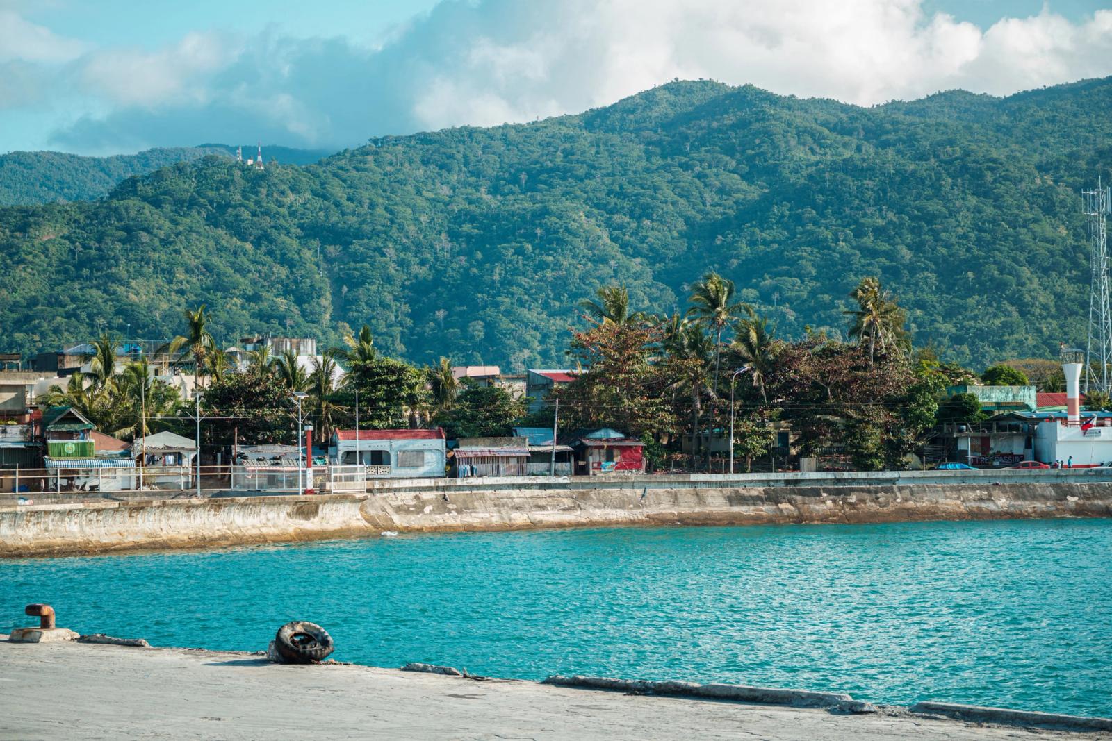 Serene waterfront scene with lush mountains and vibrant blue water, embodying tropical tranquility