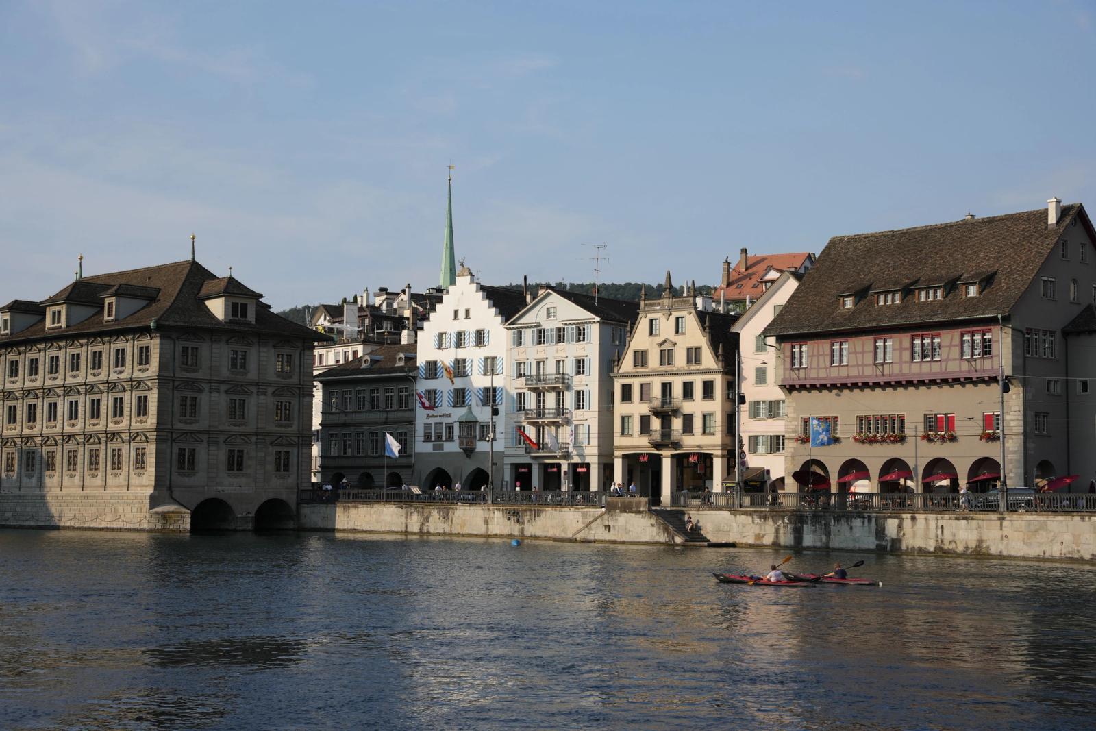 Scenic view of Zürich's historic buildings and canoeing on the Limmat River