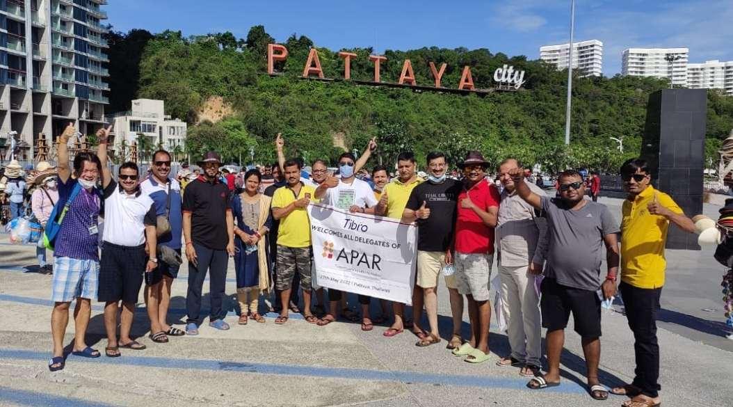 A group of people posing together with a banner