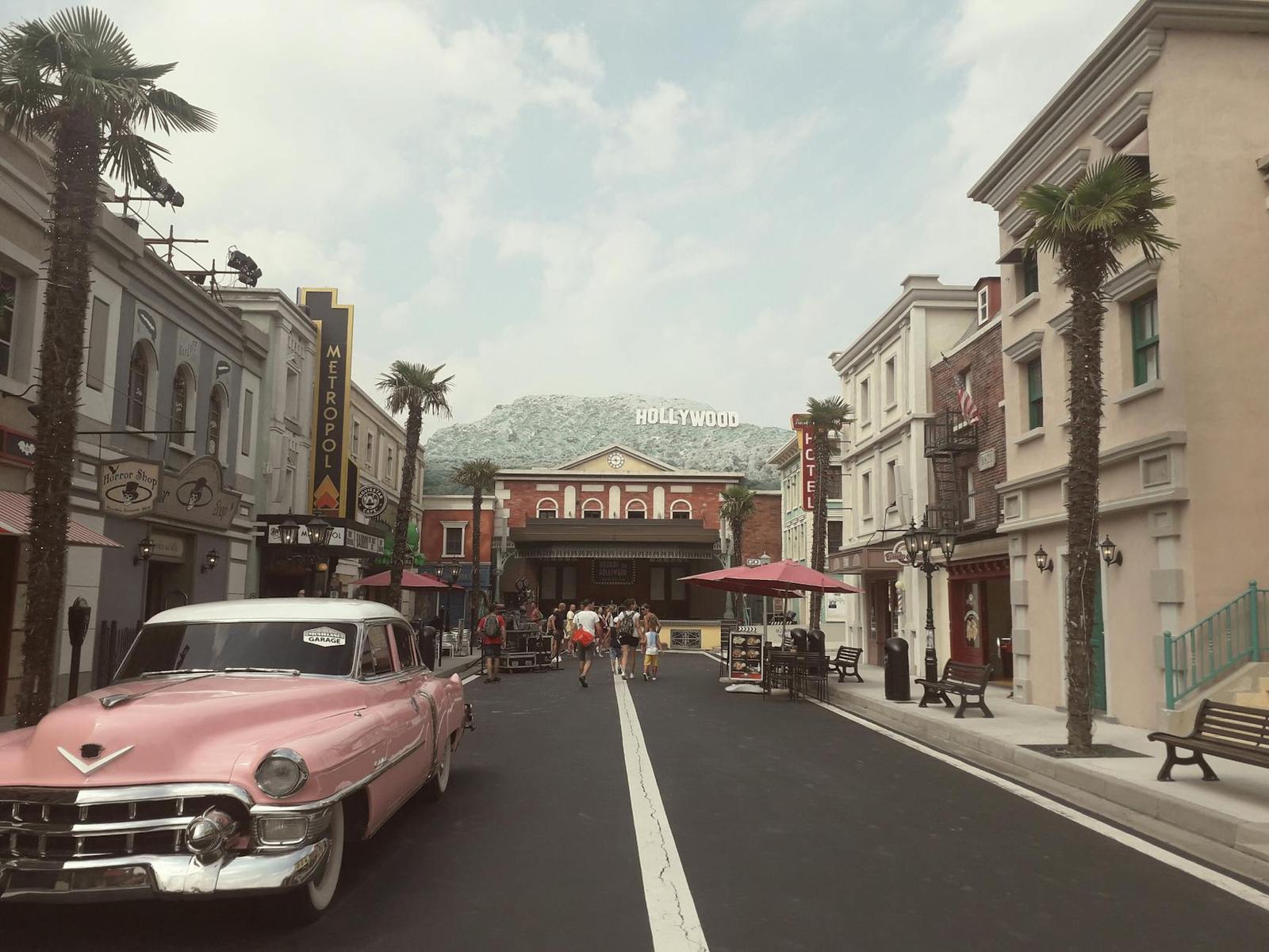 Vintage pink convertible parked on a themed studio backlot street