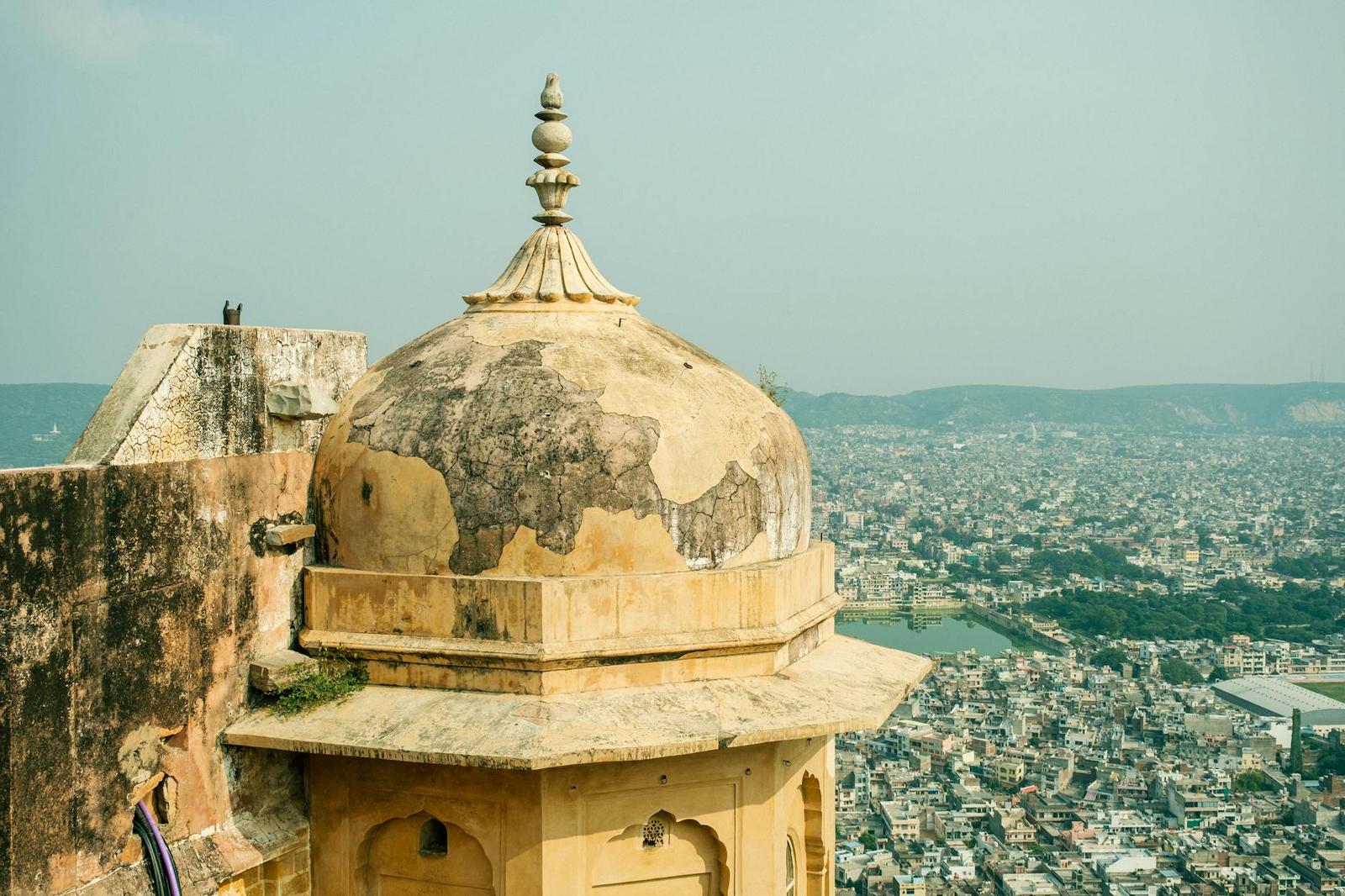A weathered stone dome overlooking a sprawling city and lake