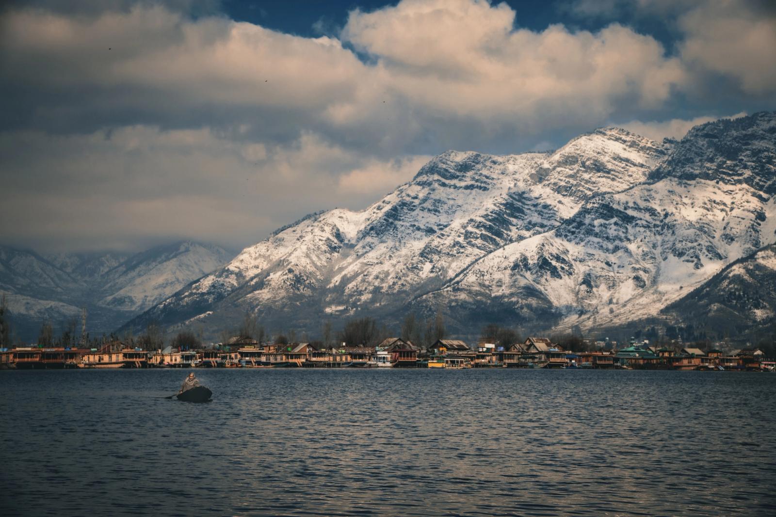 Beautiful snowy mountains overlooking Dal Lake in Srinagar during winter, capturing serene urban and natural beauty