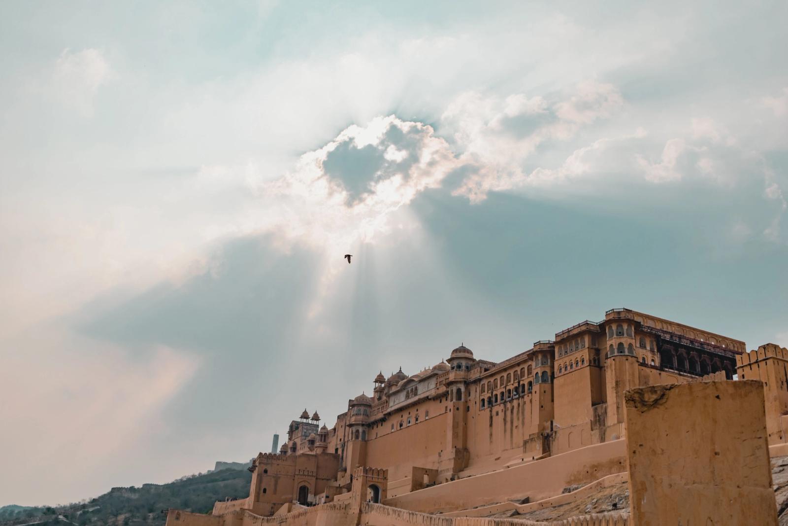 A striking image of a grand fort under a dramatic cloudscape with sunbeams streaming through
